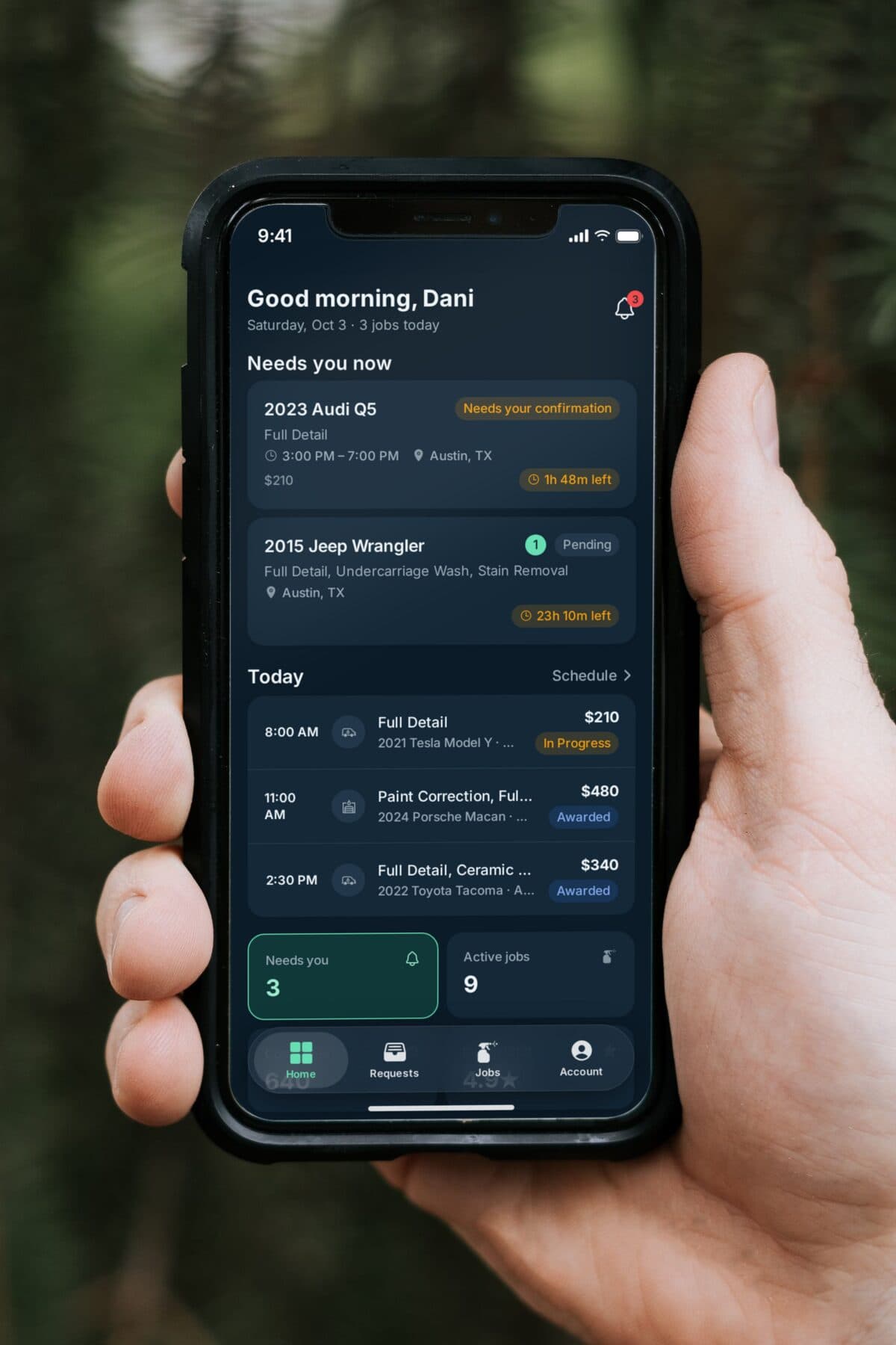 A detailer holding MotoMynt Pro: two bookings need a response, and three jobs are on today's schedule